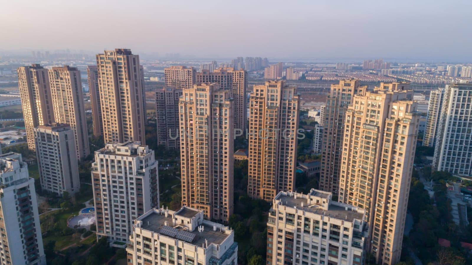 Aerial drone shot over modern residential apartment buildings on sunset in China.