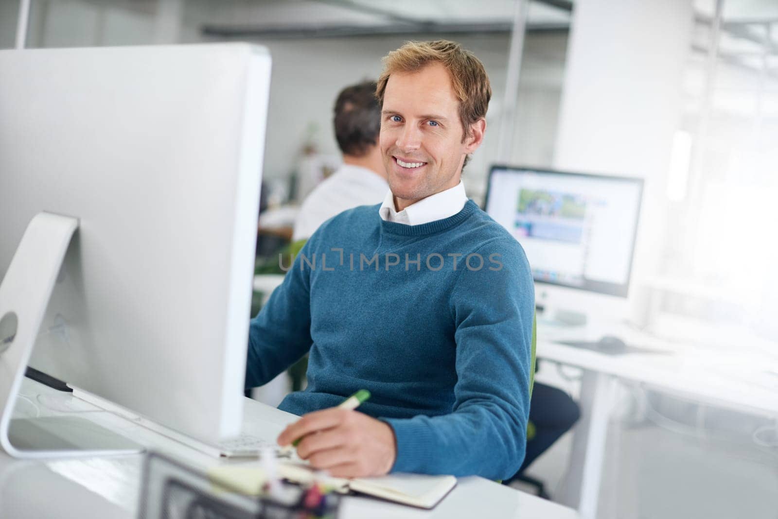 Professional, portrait and business man in office with computer for project planning, research or searching web. Analyst, desktop and employee at desk for concentration, taking notes or information.