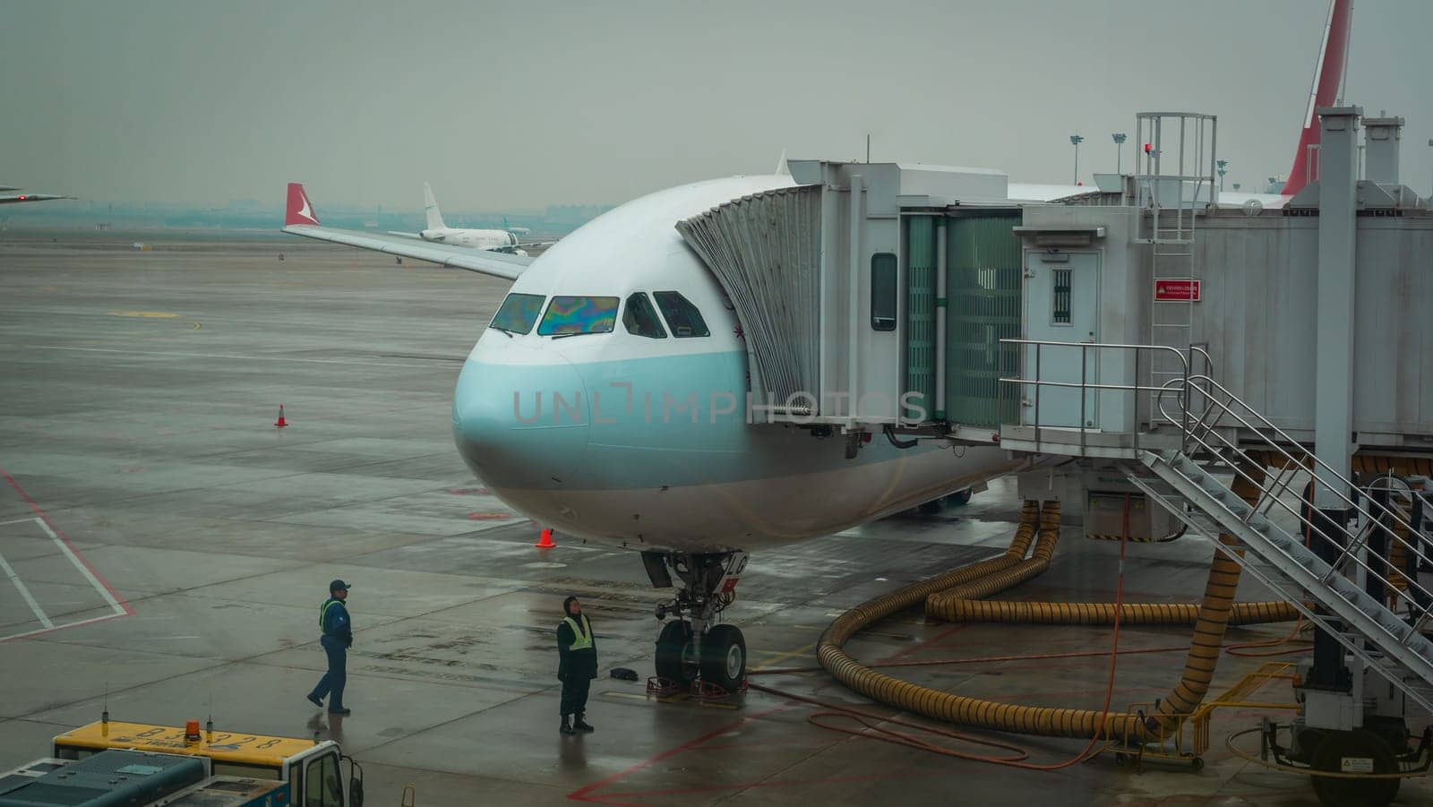 Airplane ready for boarding in Shanghai airport hub on rainy day