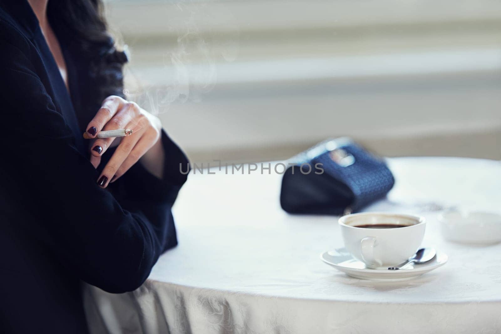 Woman, hands and smoking with coffee at cafe for morning tobacco, caffeine or nicotine. Closeup of female person or smoker with cigarette, cappuccino or americano at vintage or retro restaurant.