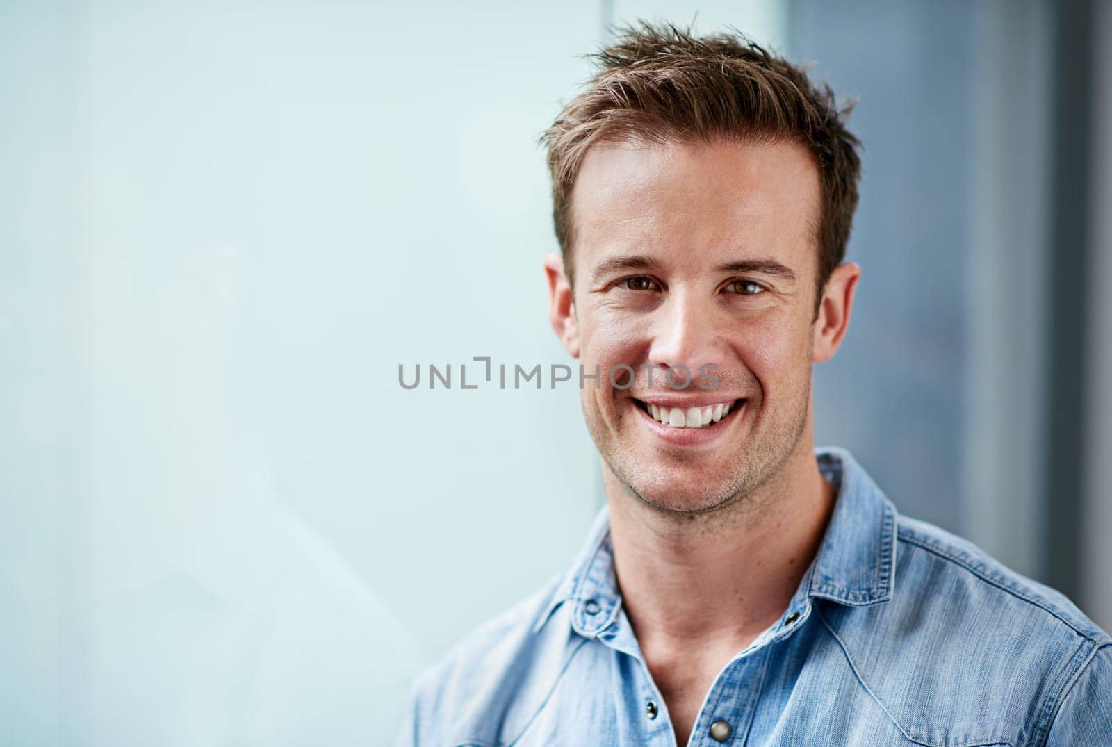 Portrait, creative and happy business man in office at startup, company or workplace for career on mockup space. Face, professional entrepreneur and smile of employee, worker or designer in Greece.