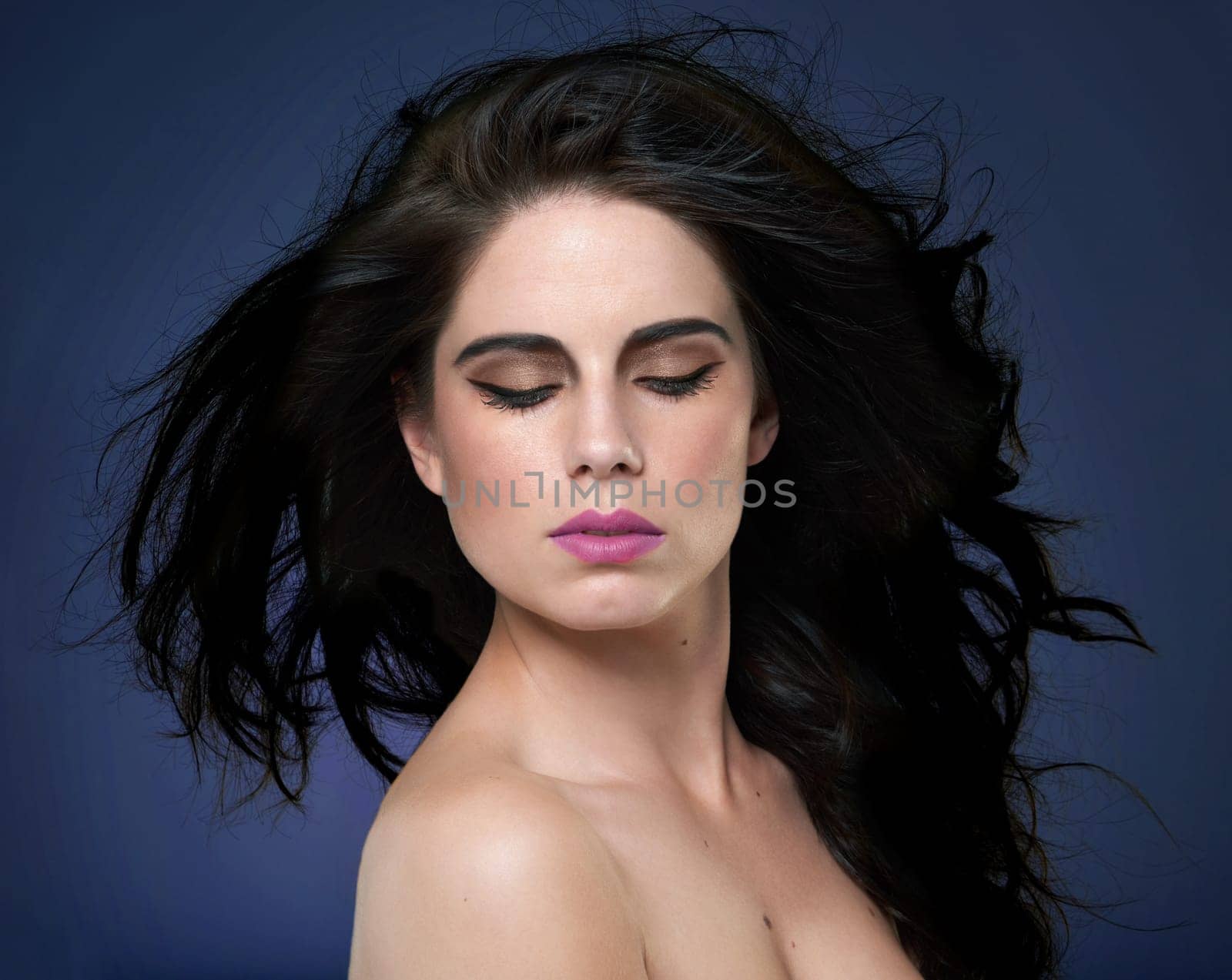 Calm, beauty and woman in studio for hair cosmetics, shine and luxury wellness on blue background. Makeup, glamour and model with shampoo, scalp or glow haircare results, growth and smooth texture.