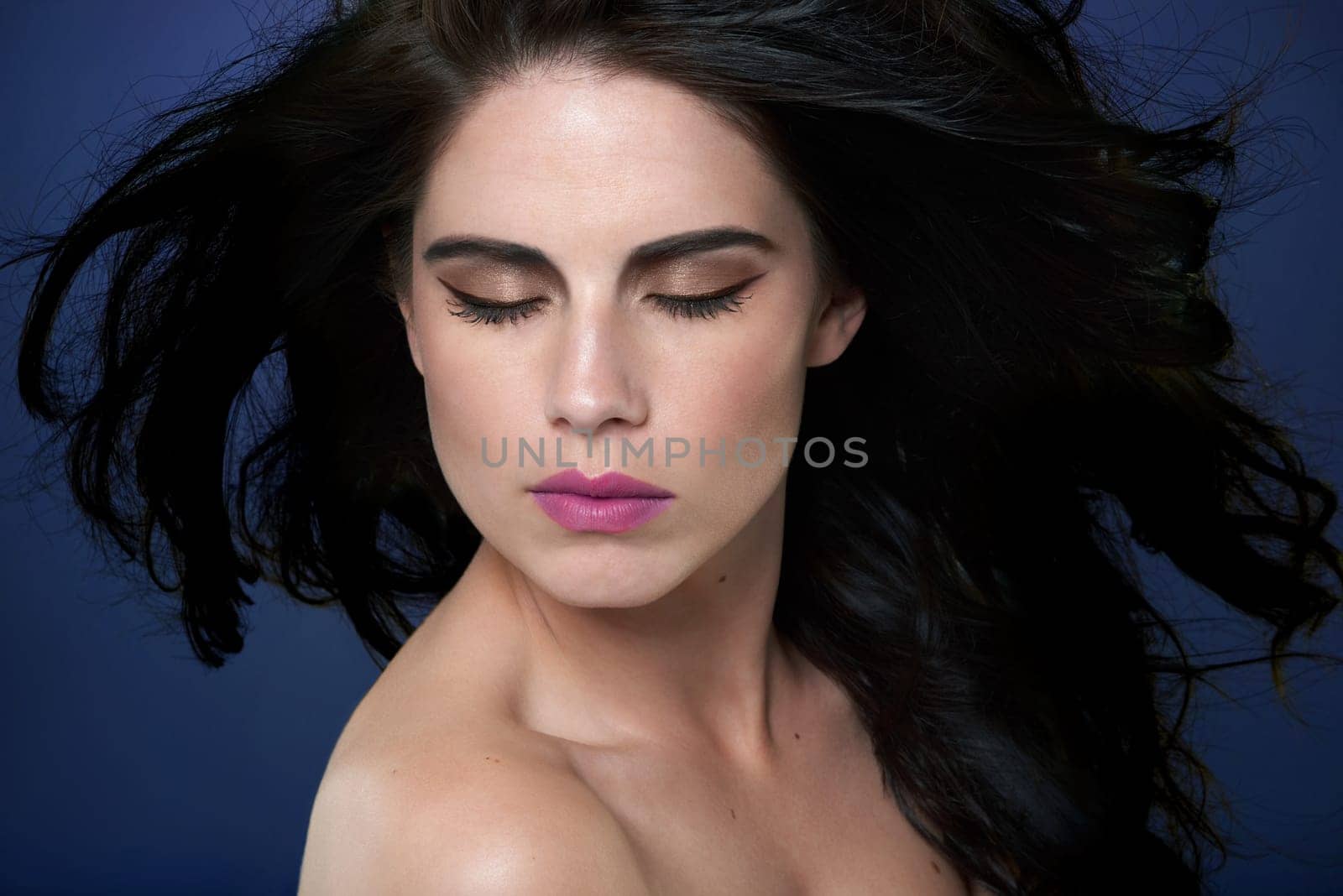 Beauty, makeup and woman in studio for hair cosmetics, shine and luxury glamour on blue background. Wellness, skin and model with shampoo, scalp or glow haircare results, growth and smooth texture.