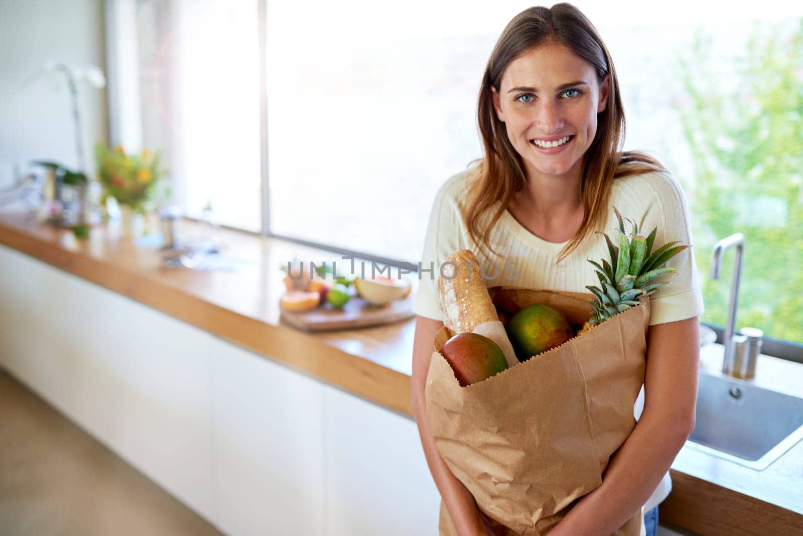 Groceries, paper bag and portrait of woman in kitchen with food, cooking or meal prep with smile. Diet, wellness and person in home with shopping, delivery and ingredients for dinner in apartment