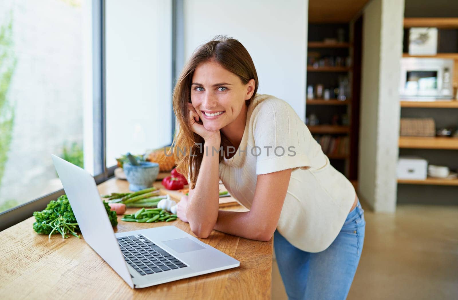 Cooking, home and woman with food, laptop and vegetable lunch for online search. Diet, wellness and girl at kitchen counter with website for recipe research, ingredients and nutrition for gut health by YuriArcurs