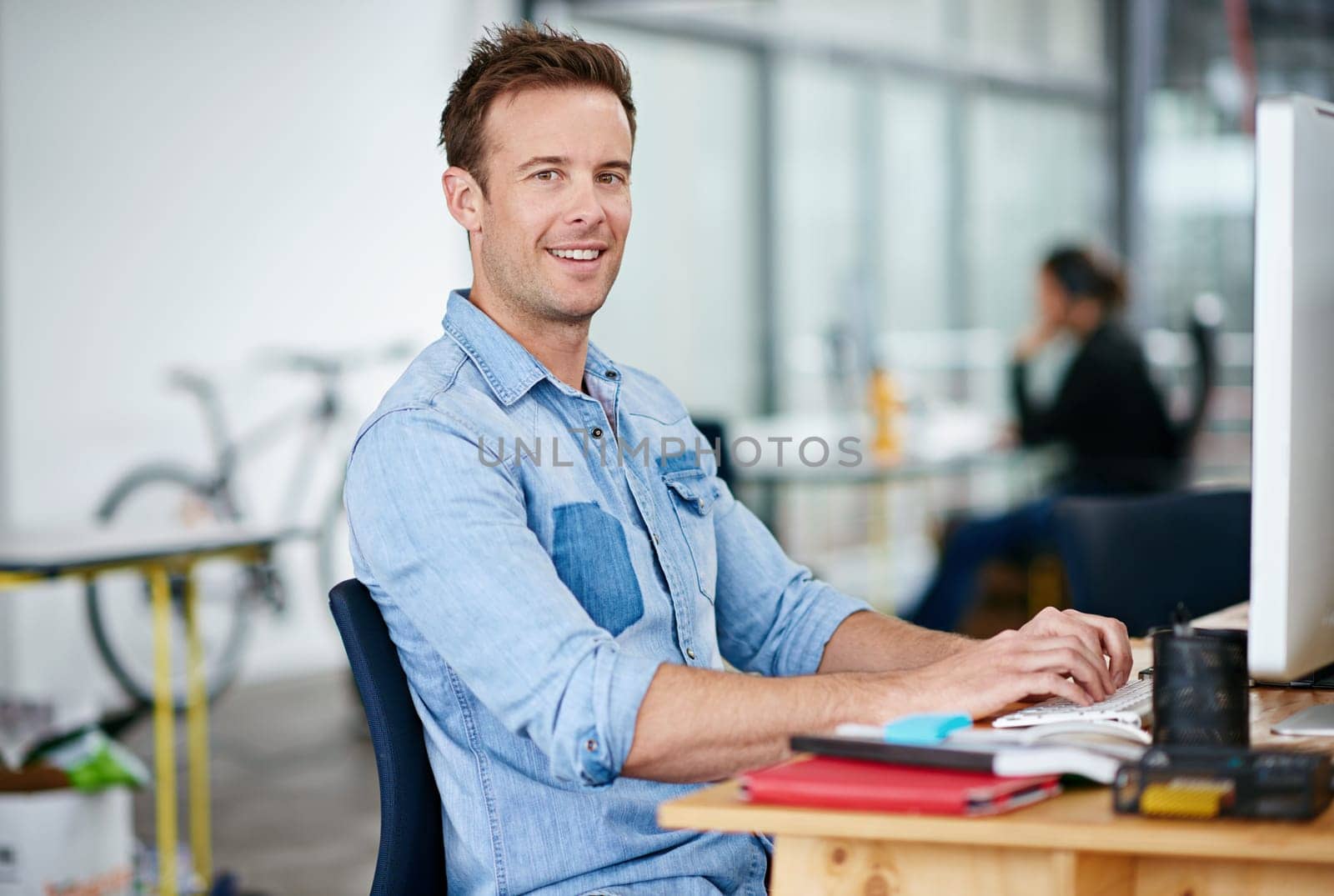 Portrait, smile and business man typing on computer in office at startup, company or workplace for career. Happy face, creative writer and entrepreneur on desktop for work email or project in Italy by YuriArcurs