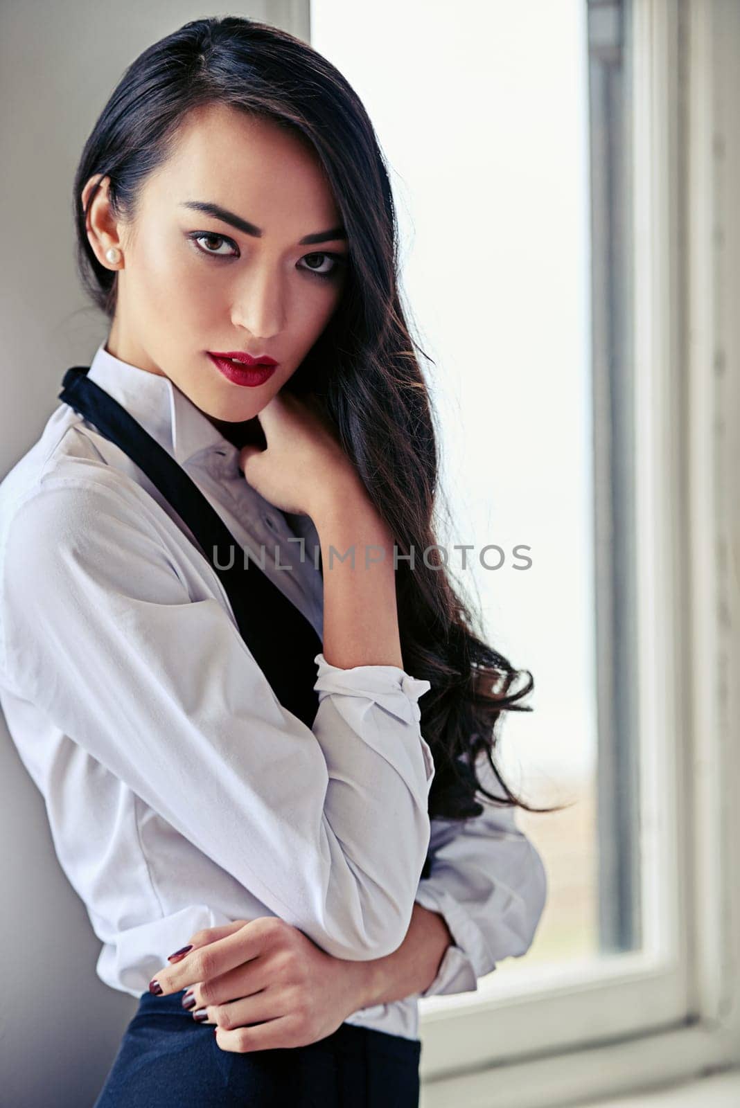 Woman, portrait and makeup with fashion by window for cosmetics, red lipstick or beauty at home. Attractive, gorgeous or young female person with confidence in stylish, seductive or classy clothing by YuriArcurs