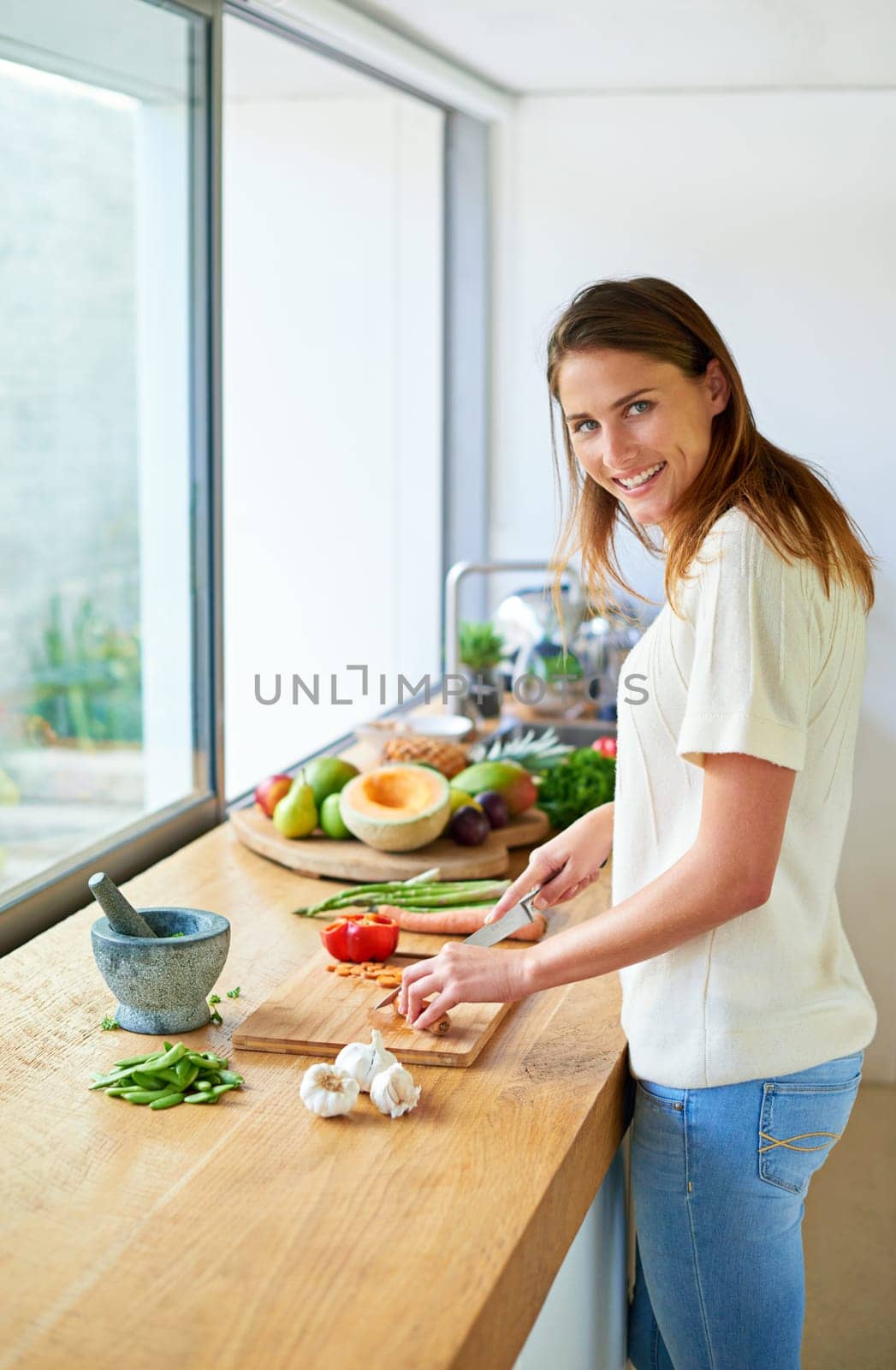 Portrait, home and woman with vegetables, cutting and smile with vegan, healthy meal and nutrition. Face, vegetarian and person in kitchen, food and chef with skills, cooking and organic ingredients by YuriArcurs