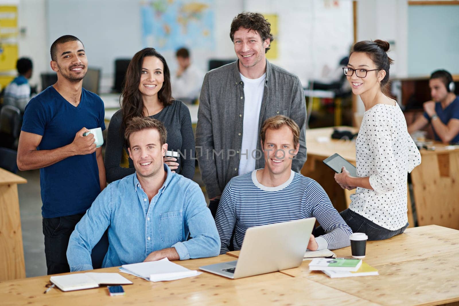 Business people, teamwork and meeting with smile, laptop documents for collaboration on startup. Happy, group of employee and team with computer for company portrait or magazine agency in office by YuriArcurs