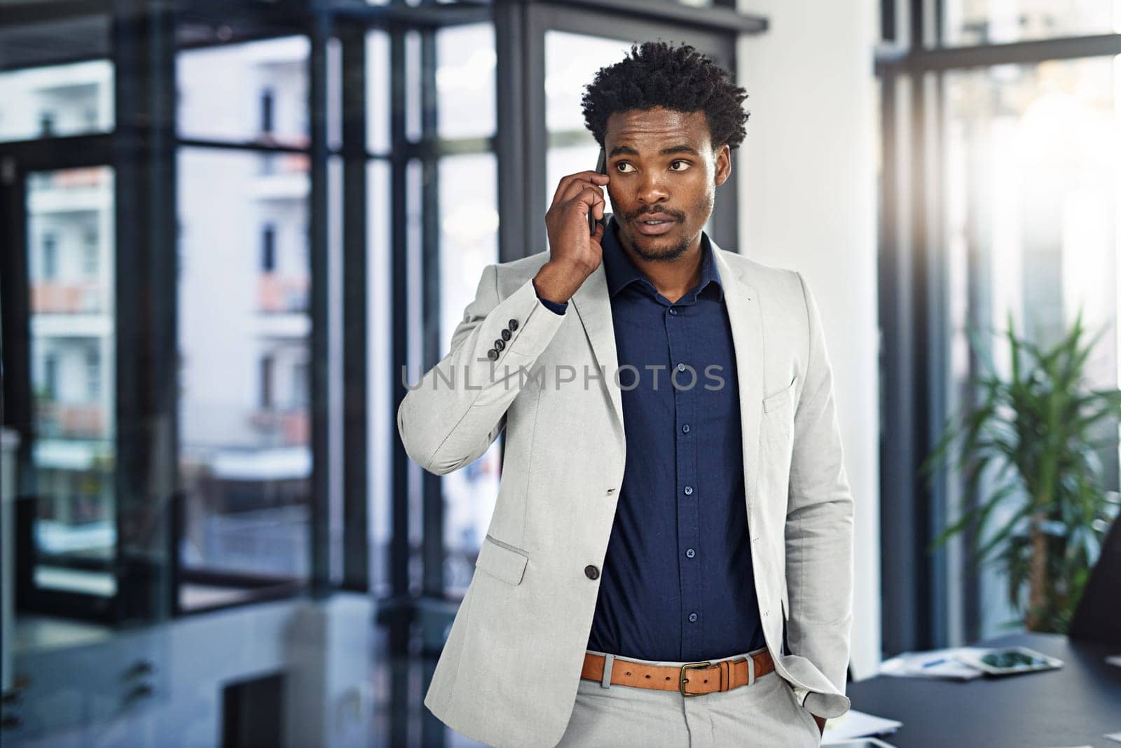 Black man, business and discussion with phone call at office for communication, proposal or corporate chat. African businessman talking or listening on mobile smartphone for conversation at workplace by YuriArcurs