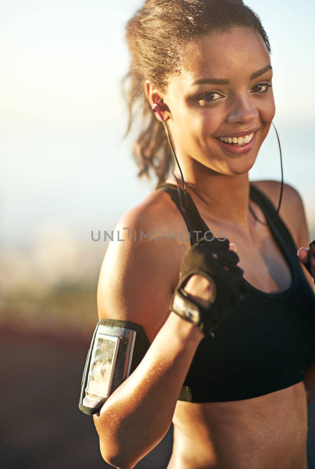 Woman, athlete or boxer in outdoor portrait for exercise, training and fitness with earphones. Female person, fists or fighter workout in nature with music playing for endurance, sports or cardio by YuriArcurs