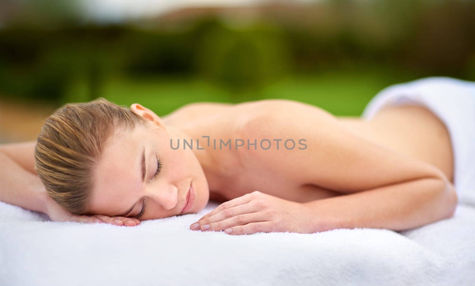 Spa, relax and massage with woman on bed for healing, treatment or pamper in peace at luxury hotel. Female person, client and sleeping with body care at resort for wellness, peace or rest on vacation.