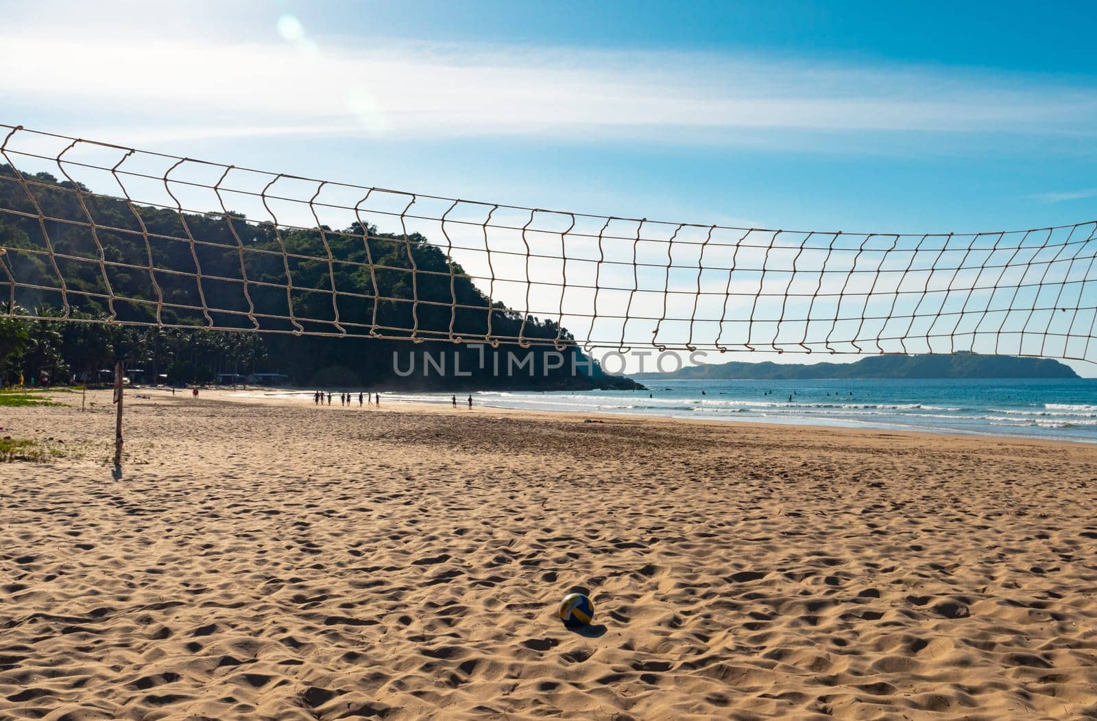 Beach Volleyball. Game ball under sunlight and blue sky with volleyball net by Busker