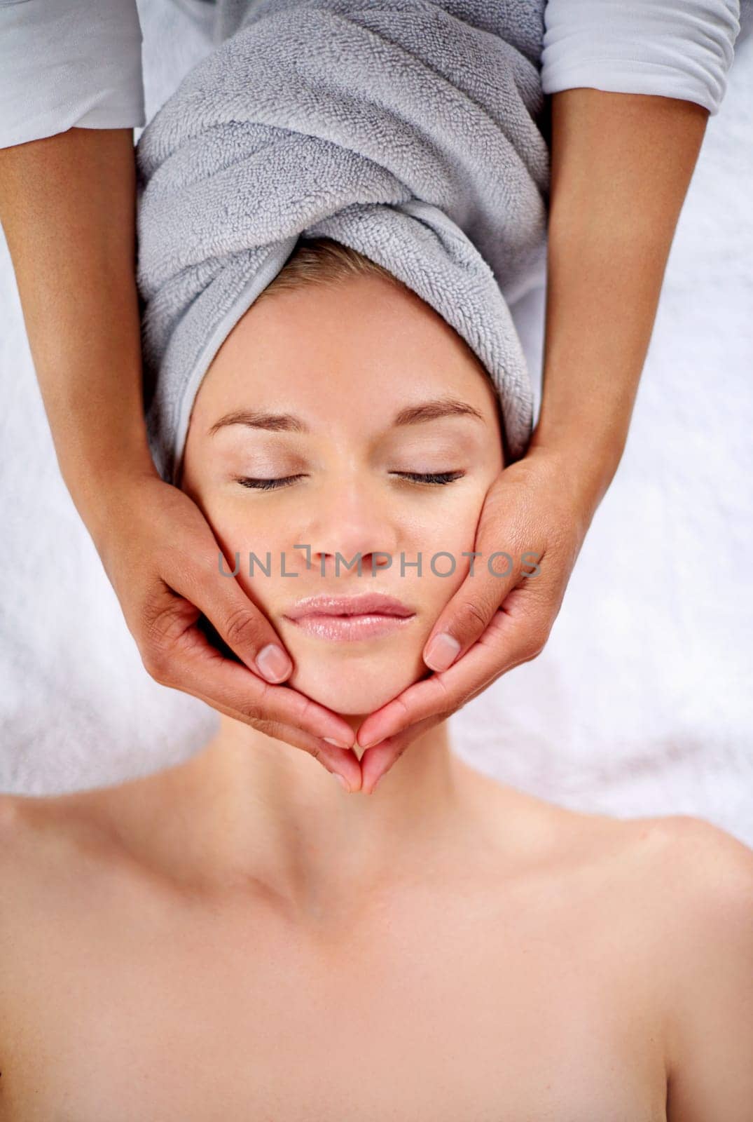 Woman, face and massage table in spa, therapy and self care for beauty salon or wellness and resting. Comfortable and resort with client, stress free and healing, calm session and cosmetology by YuriArcurs