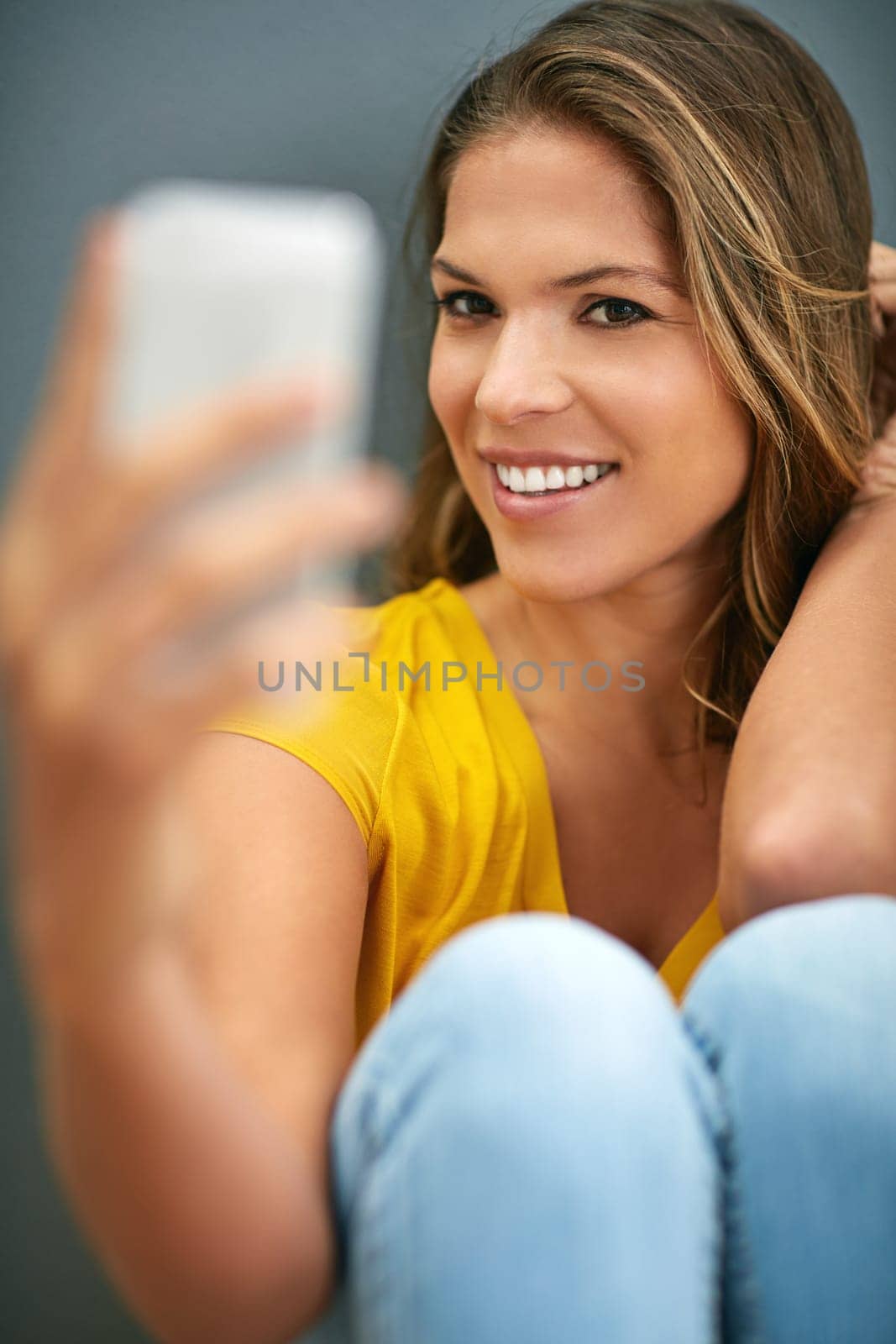 Confident, woman and smile with selfie in studio for social media post, update and online blog. Influencer, relax and happy in photography for content creation, pride and memory on grey background.