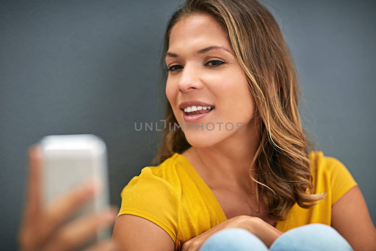 Woman, confidence and smile with selfie in studio for social media update, memory and online blog. Influencer, network and happy in photography for content creation, post and pride on grey background.