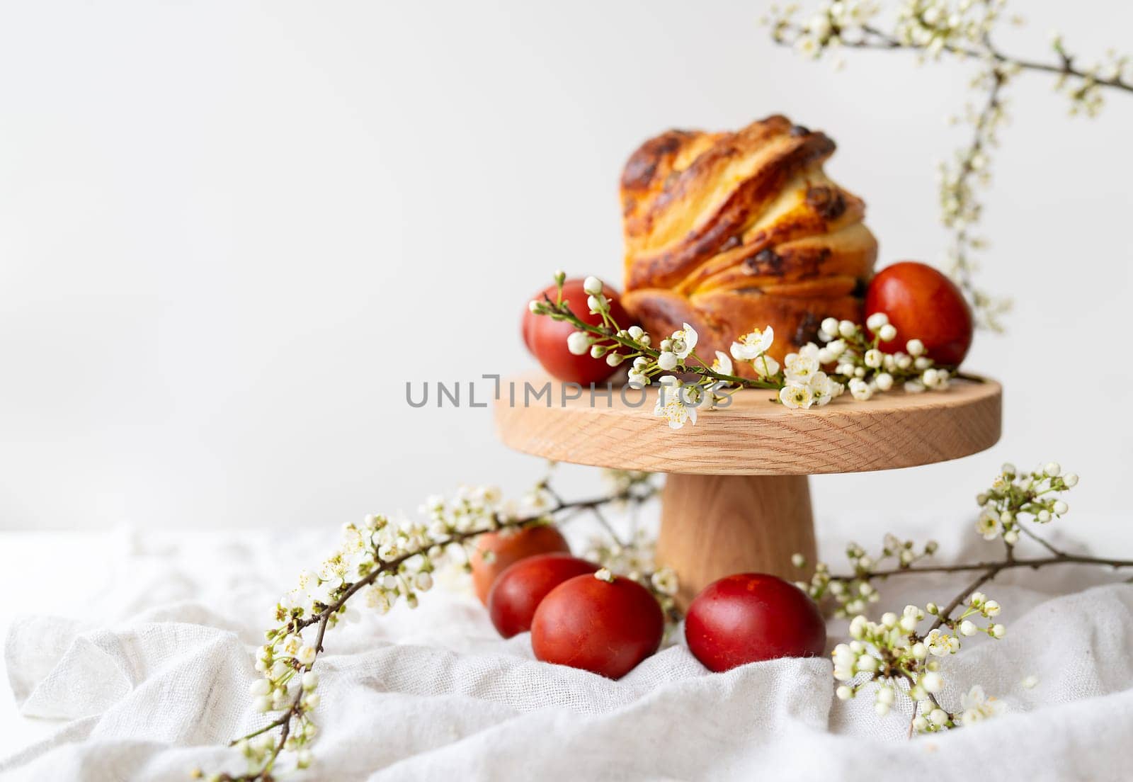 Festive table setting, Easter pastries on a wooden stand and cherry blossoms. Easter holiday concept