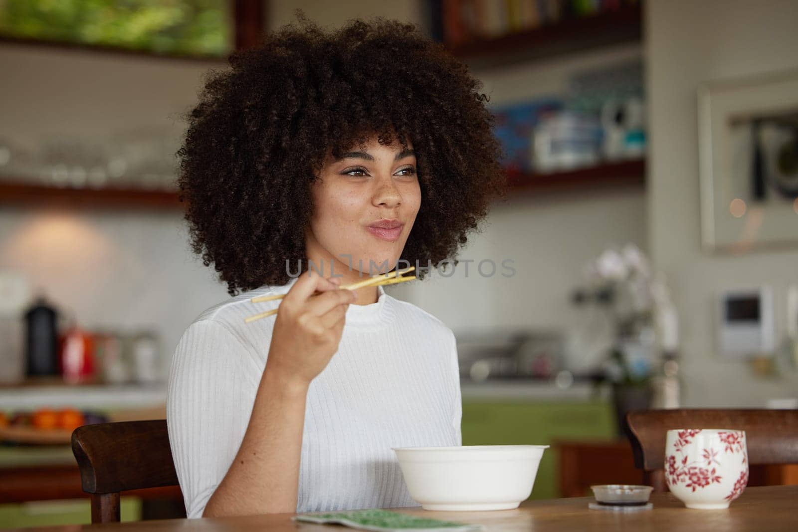 Black woman, chopsticks and food for lunch in kitchen fine dining for healthy diet, experience or hunger. Female person, plate and asian cuisine or ramen in home for snack, nutrition and eating by YuriArcurs