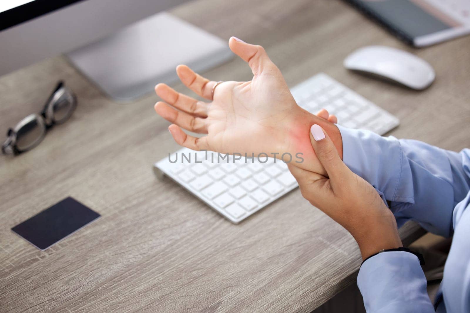 Hands, wrist pain and injury at desk in office with red glow, overlay and massage with burnout. Person, arthritis or carpal tunnel syndrome with emergency, strain and fatigue by computer in workplace by YuriArcurs