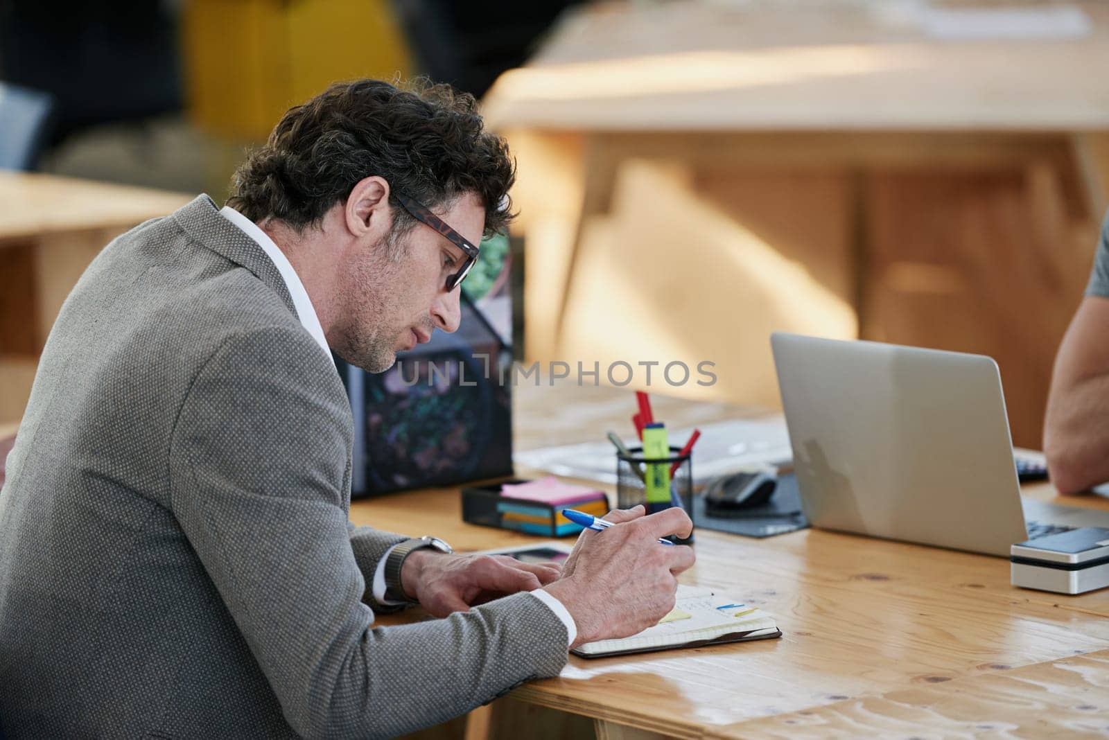 Businessman, notebook and brainstorming at desk for project, planning and teamwork in office. Mature male person, collaboration and research in workplace for start up company and global enterprise by YuriArcurs