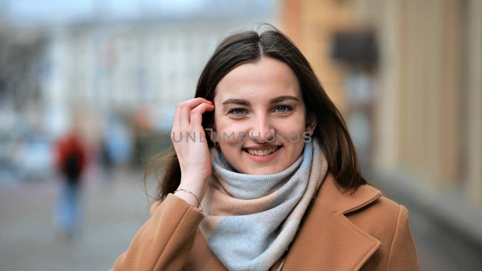 Beautiful young girl portrait in a coat in spring on a city street