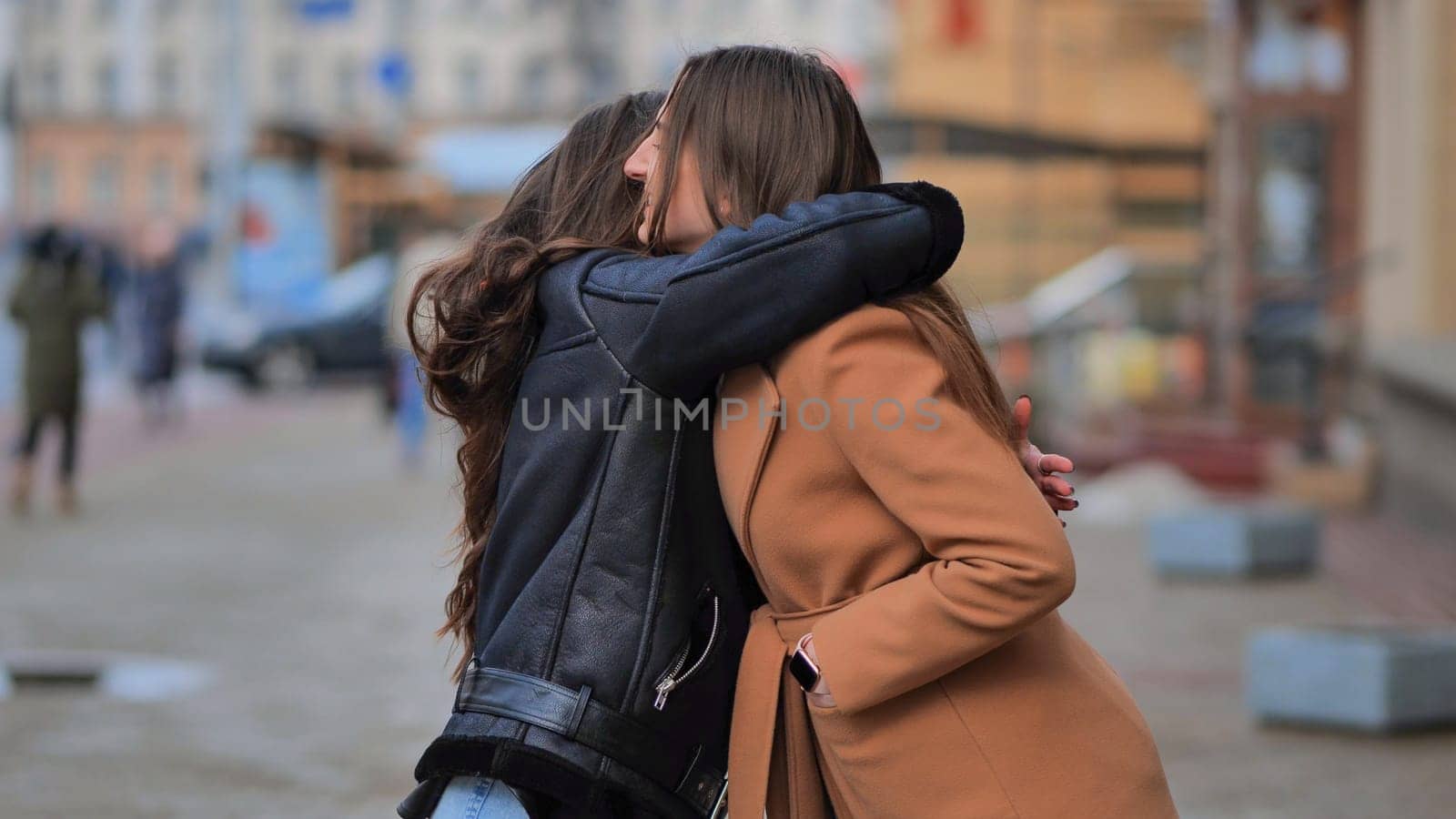Two best friends meet on the streets of the city and hug