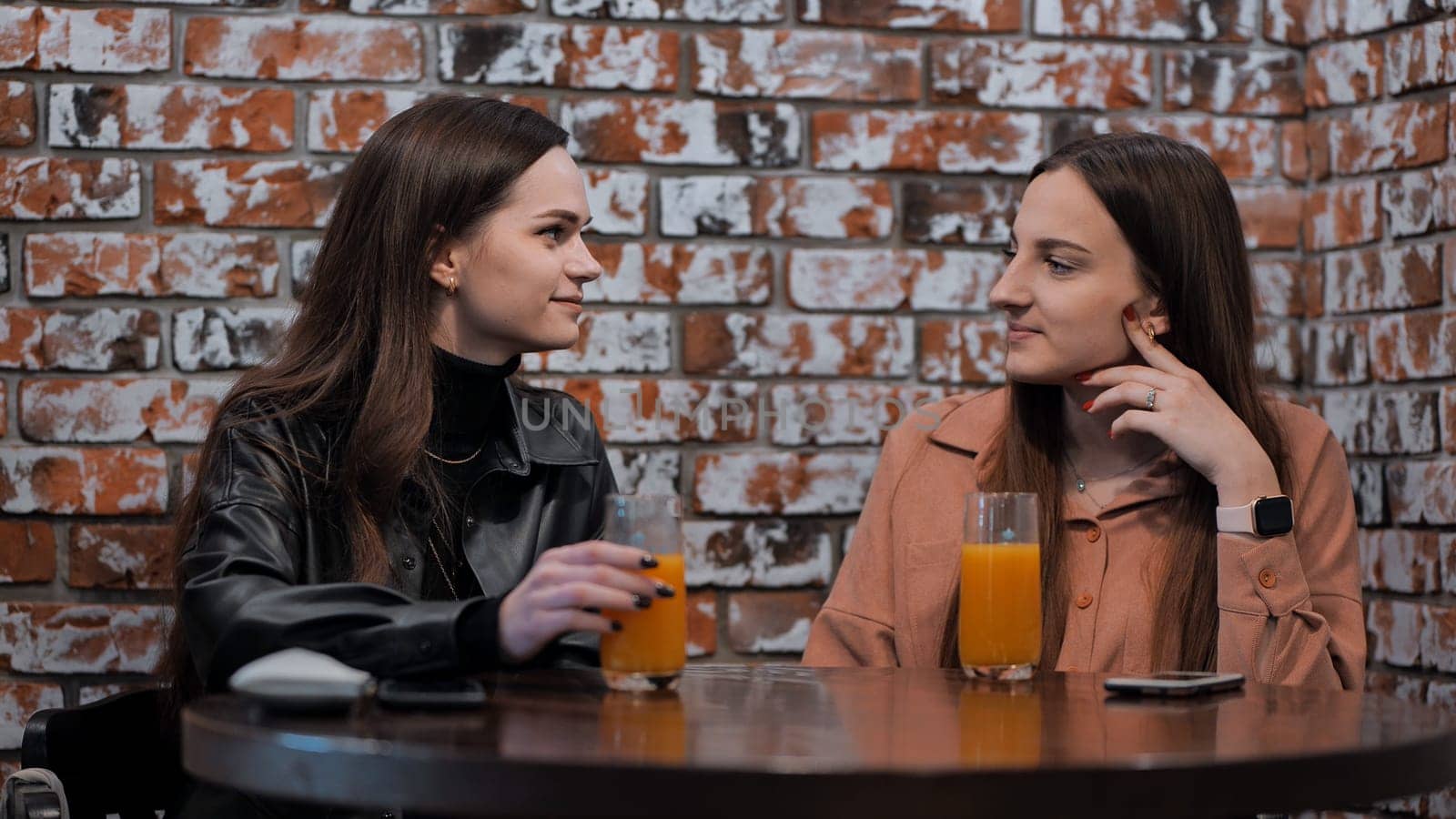 Girls at the cafe drinking orange juice. by DovidPro