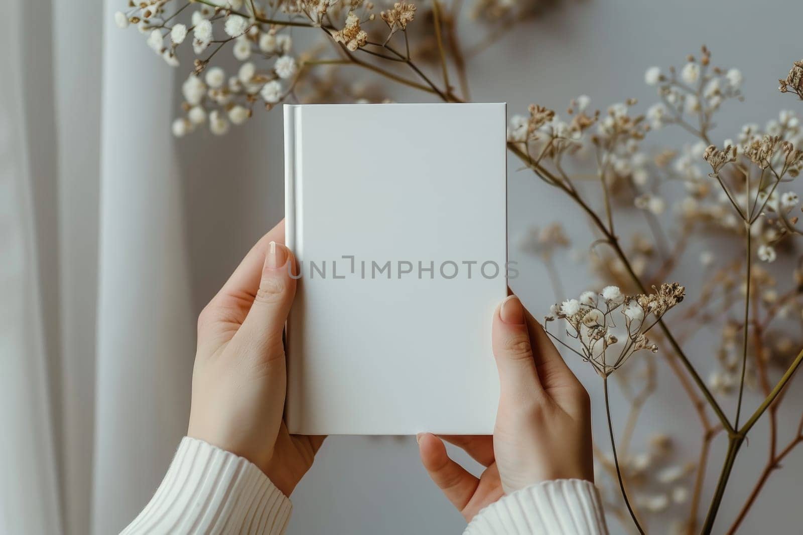 Hand holding white blank book mockup, isolated. by Chawagen