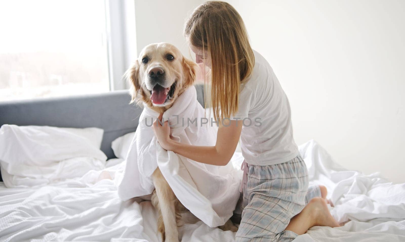 Happy Little Girl Playing With Her Pet Golden Retriever Dog, Wearing In A Blanket by GekaSkr