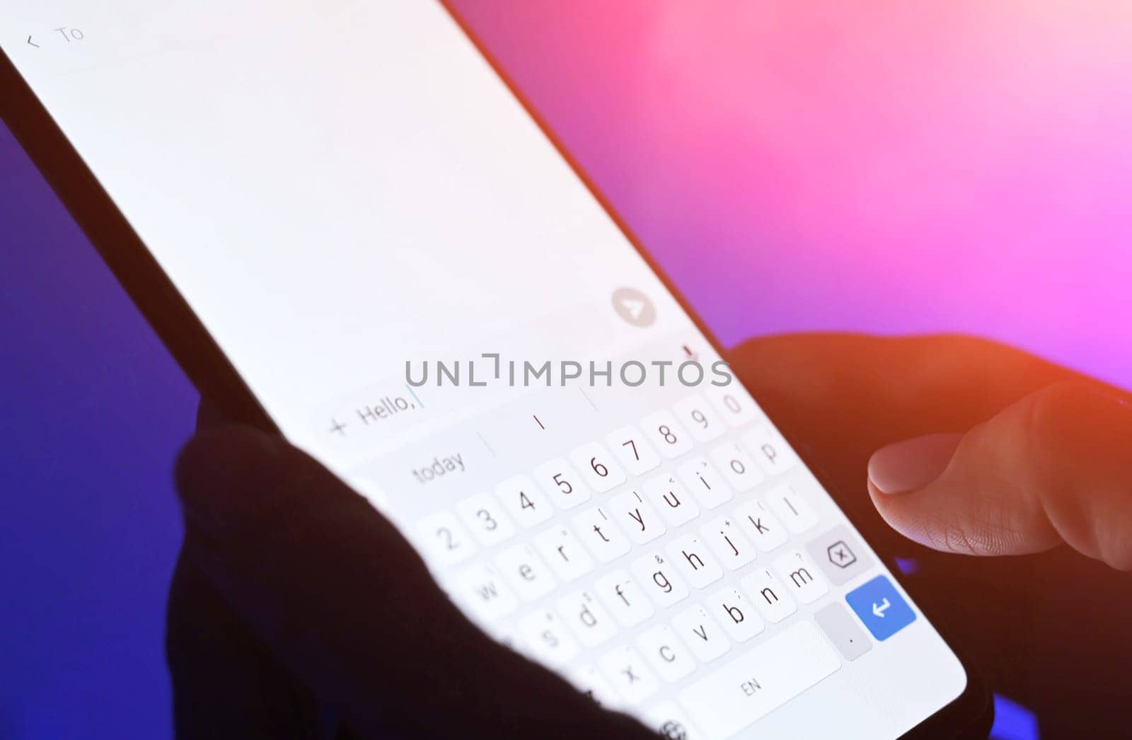 Girl typing message on a smartphone against blue background. Close up viwe of white sceen.