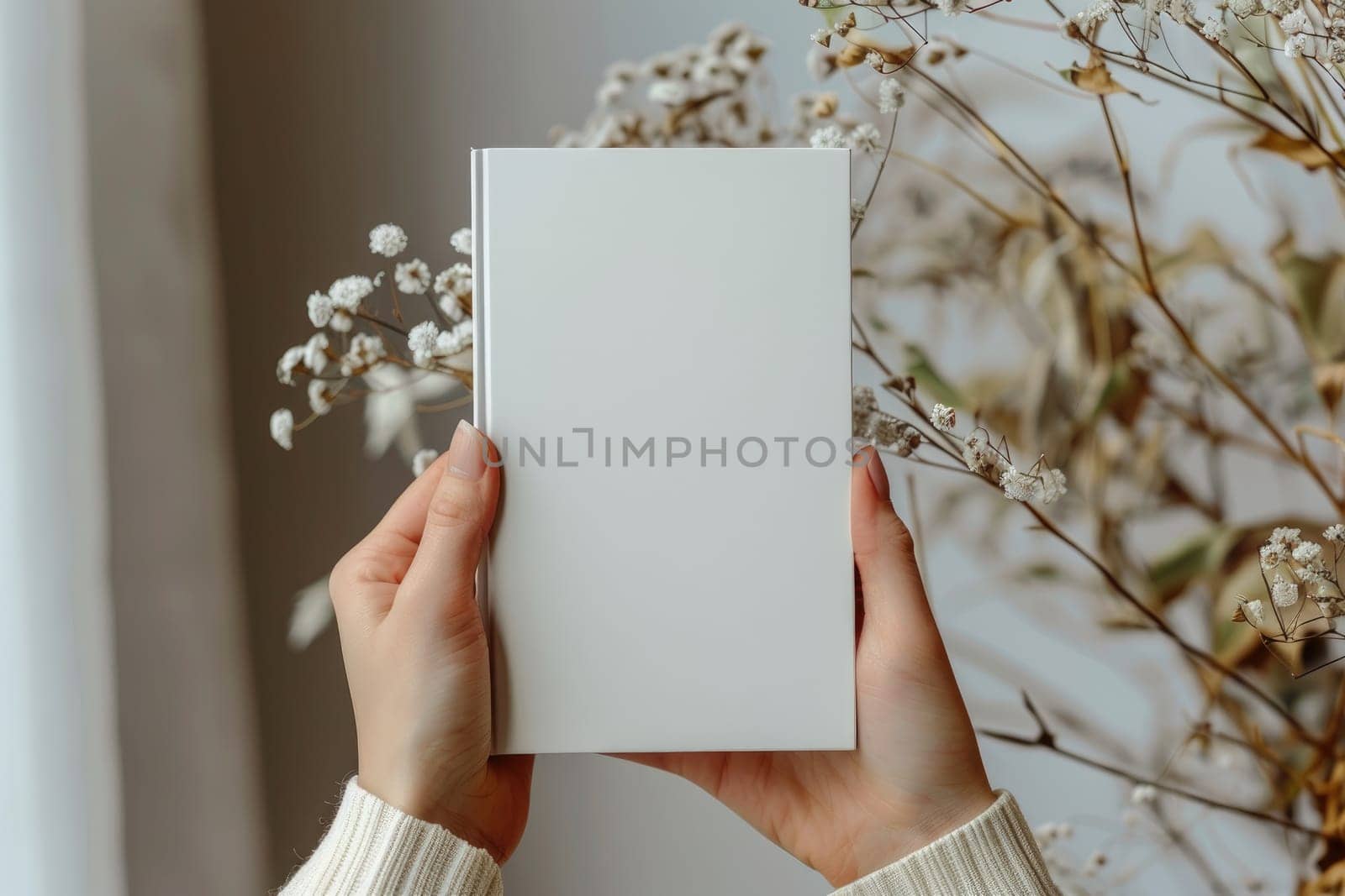 Hand holding white blank book mockup, isolated. by Chawagen