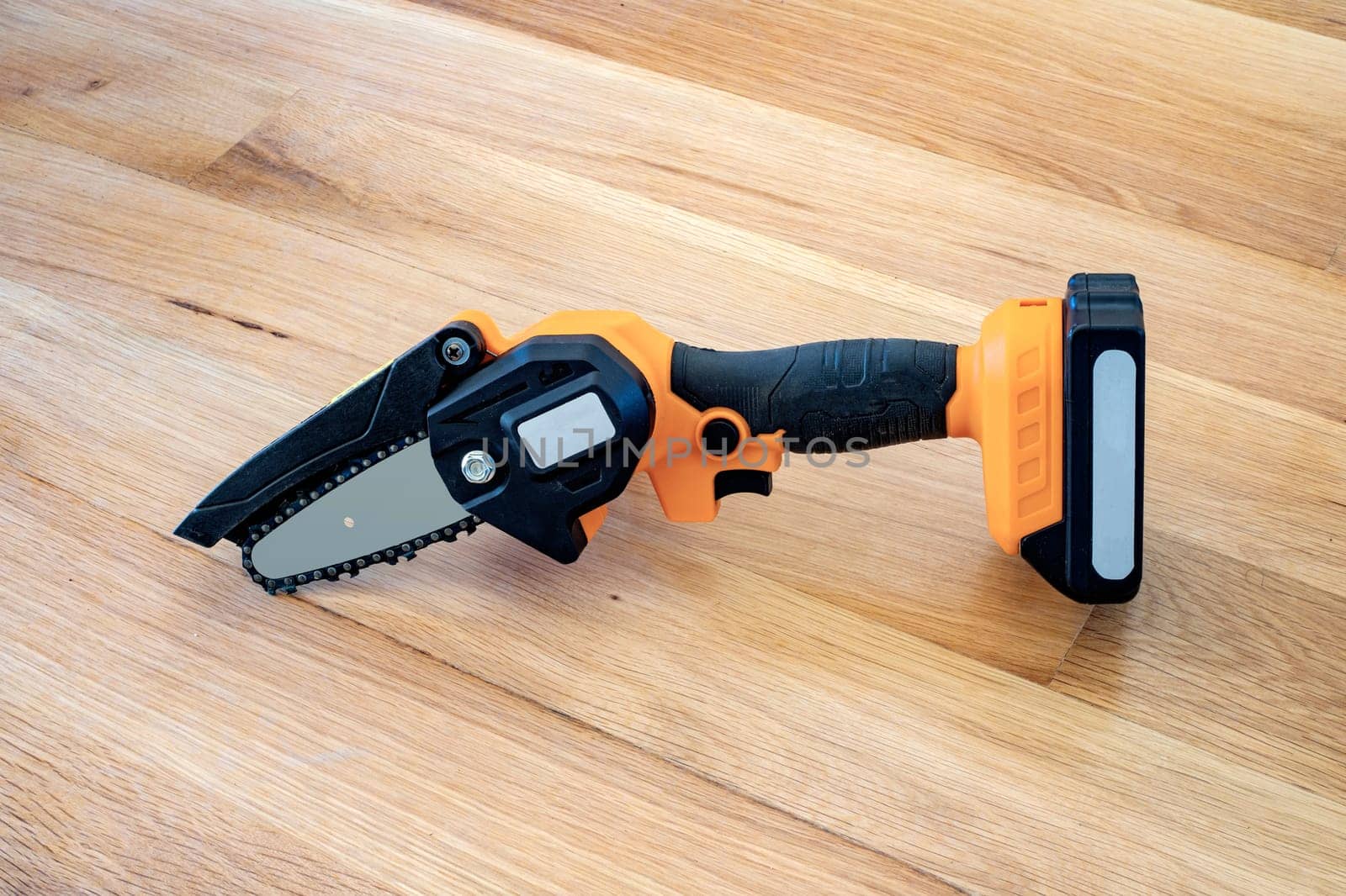 small accumulator chainsaw to trim broken branches of a tree 