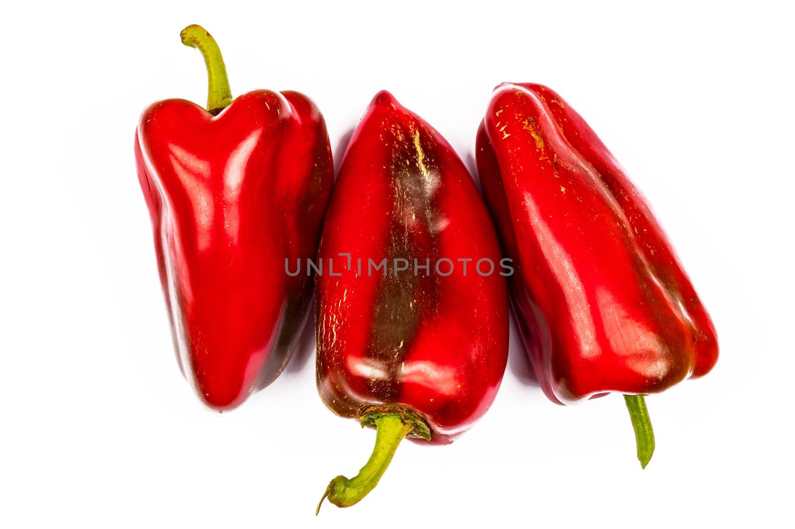 view of three big red peppers, isolated on a white background