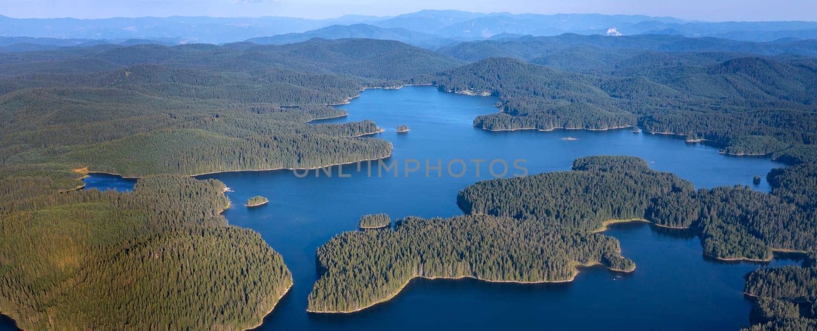 Beautiful panorama of blue water and green forest. Aerial view at Dam Shiroka Poliana, Bulgaria.