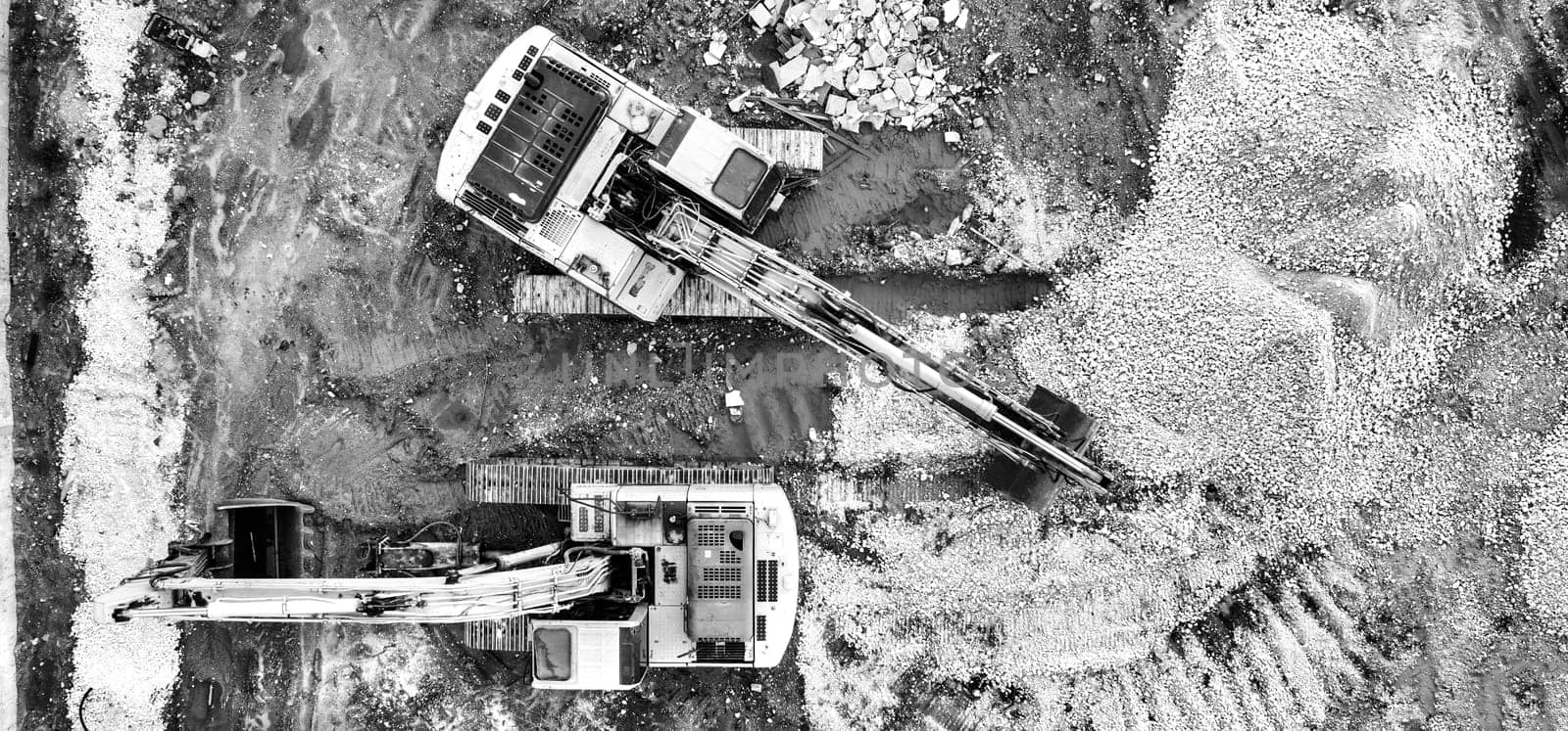 Stunning aerial view of the stopped yellow excavators at a construction site by EdVal