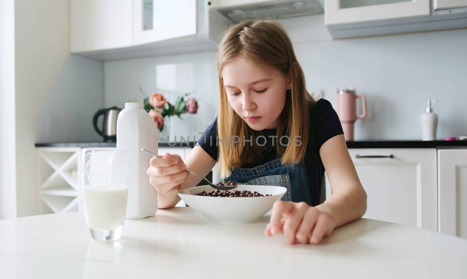 Girl Eating Brown Chocolate Balls Dry Breakfast In The Kitchen In The Morning by GekaSkr