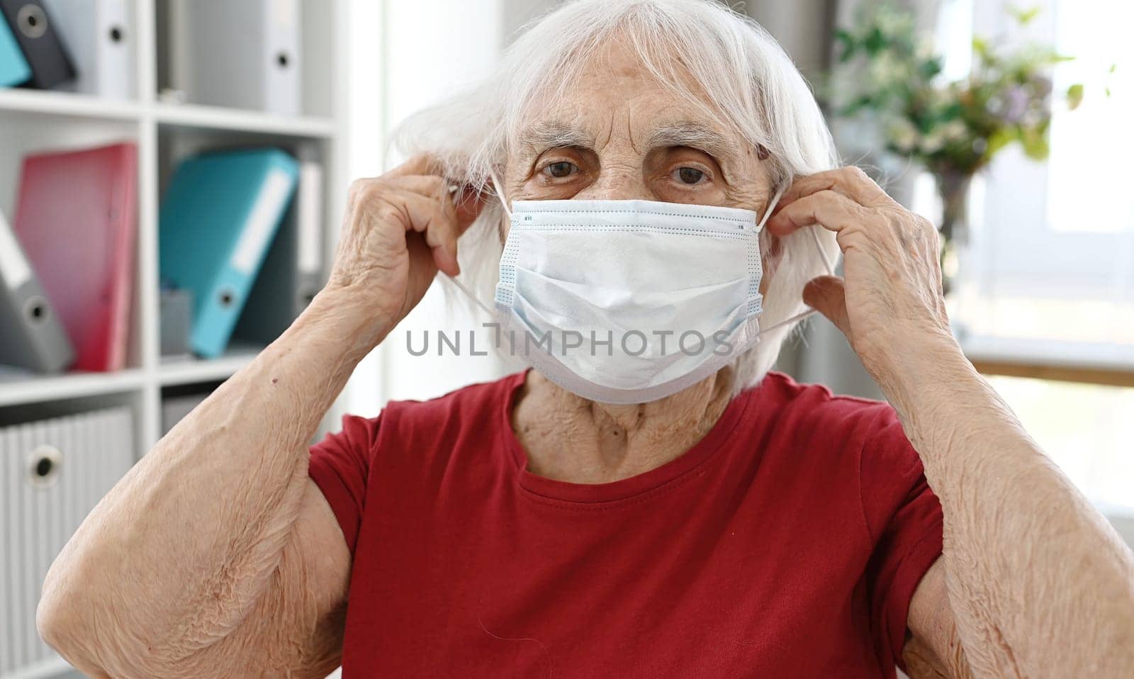 Elderly Woman Puts On Protective Medical Mask by GekaSkr