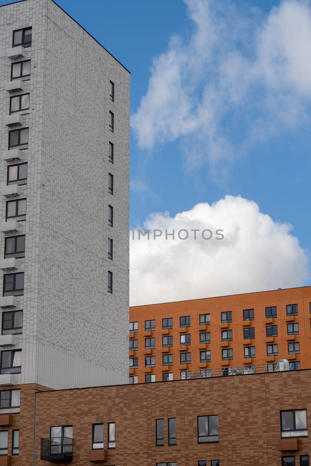Residential complex in Moscow. New buildings in Moscow, high-rise bright creative house and against the sky. There are many apartments with Windows.
