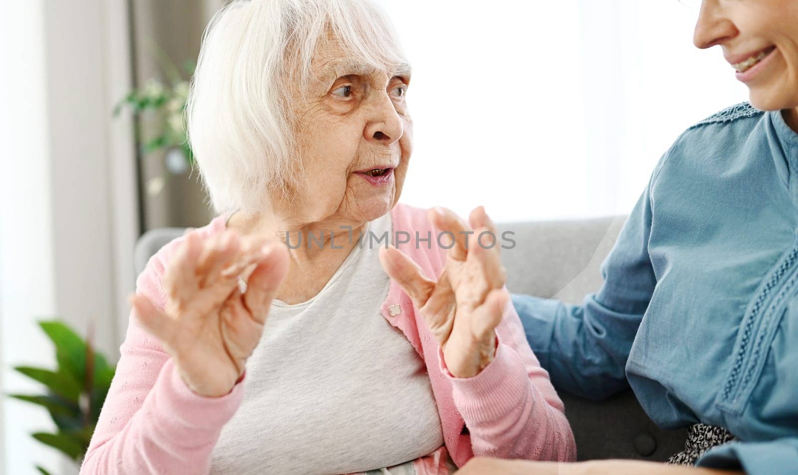 Old Grandma Chats With Granddaughter On Hallway Couch by GekaSkr