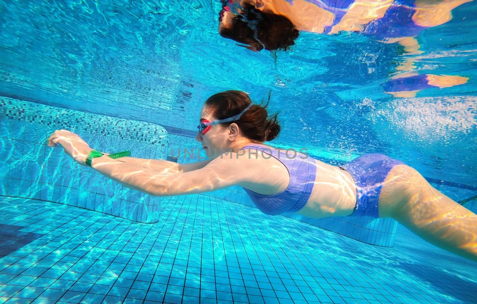 Beautiful girl swimming underwater in pool by GekaSkr