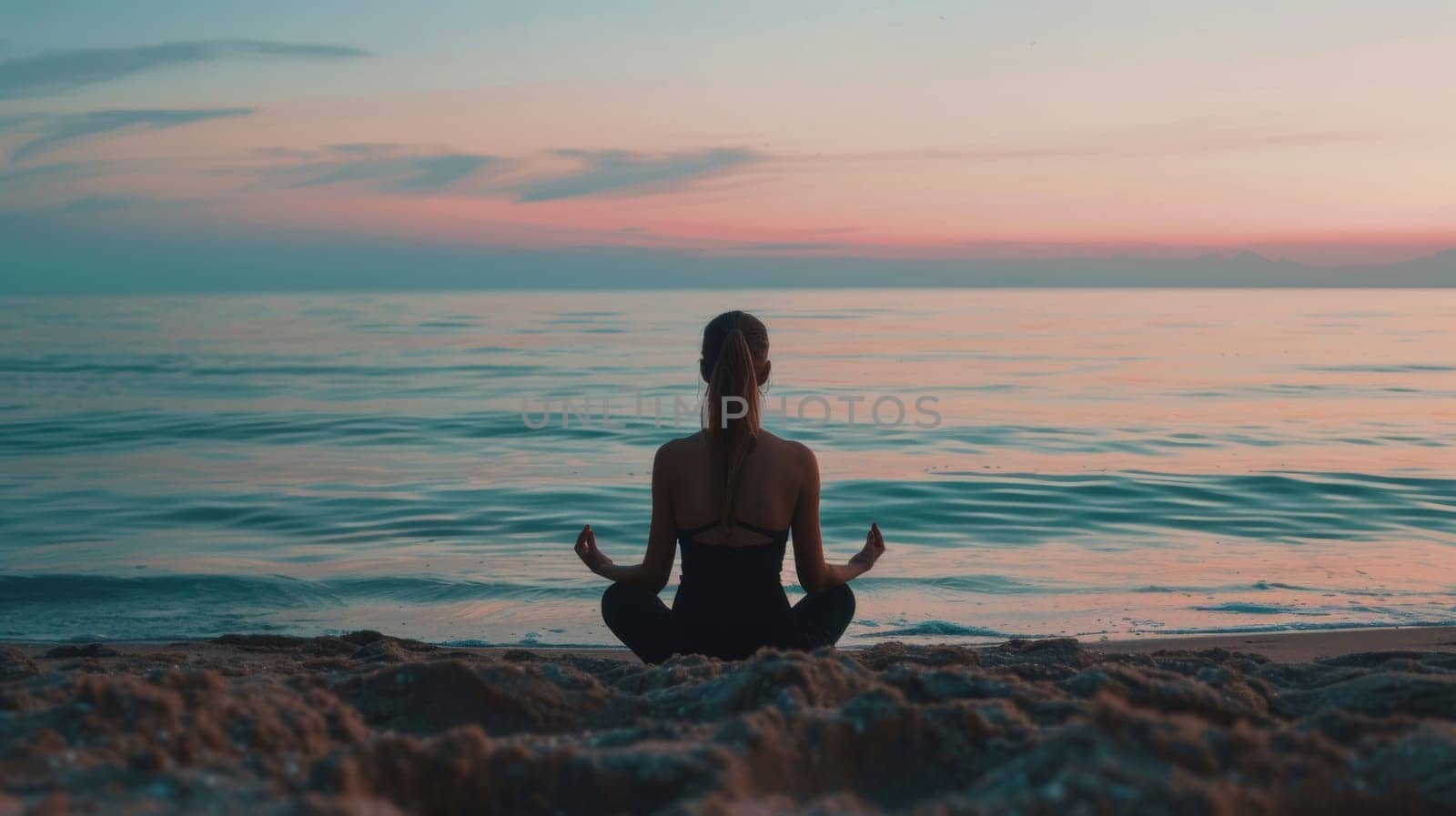 Woman meditating on beach at sunset