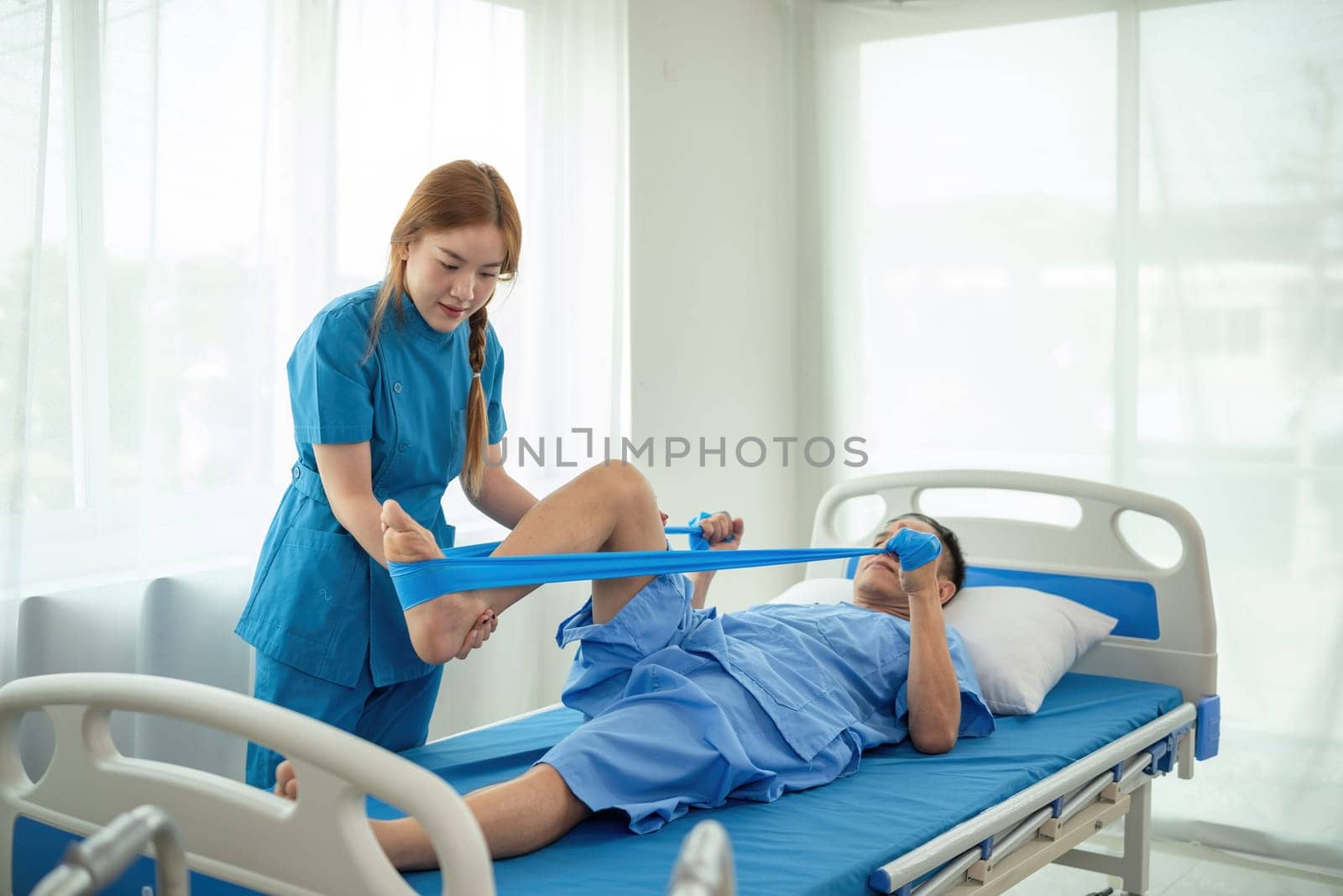 A sick caregiver or young nurse is helping a patient who is rehabilitating with physical therapy at the hospital. by wichayada