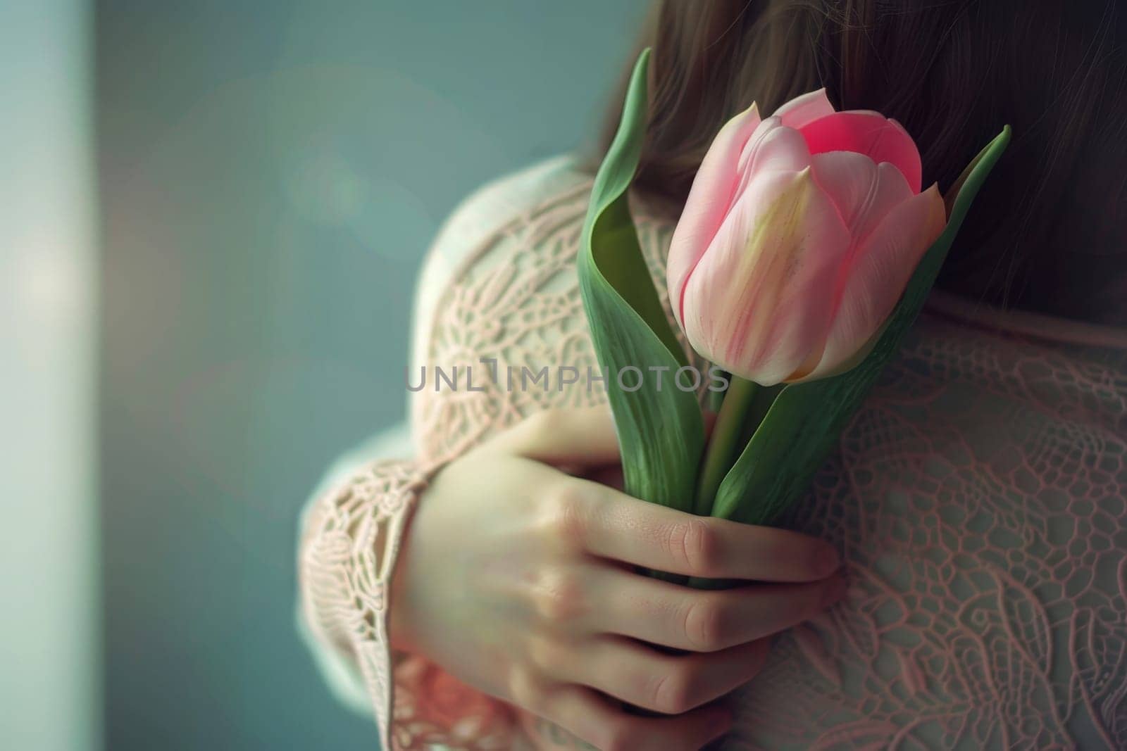 A woman is hugging a child and there are pink flowers in the background.