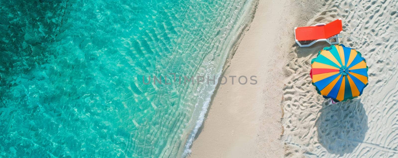 Aerial view of a tropical beach with a colorful umbrella and a sun lounger