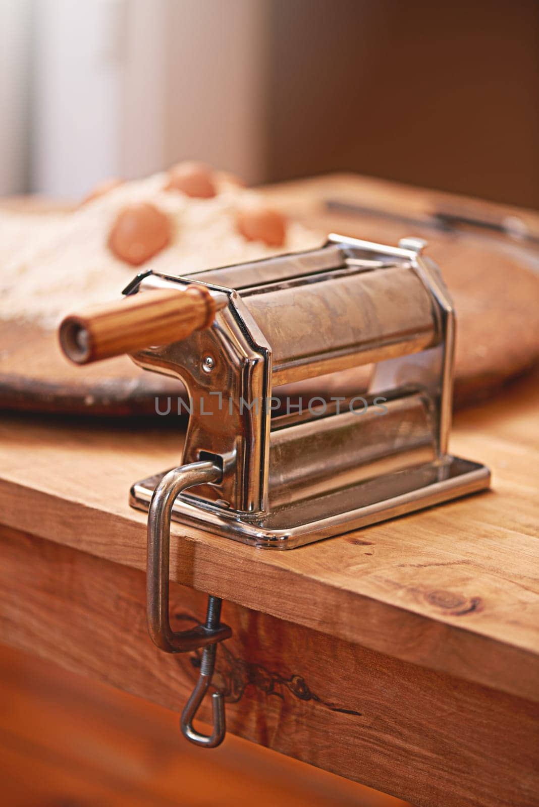 Cooking, dough and pasta maker in kitchen on table, counter and wooden board for cuisine. Food, baking and culinary tool, machine or utensil for flour, ingredients and eggs for homemade noodles by YuriArcurs