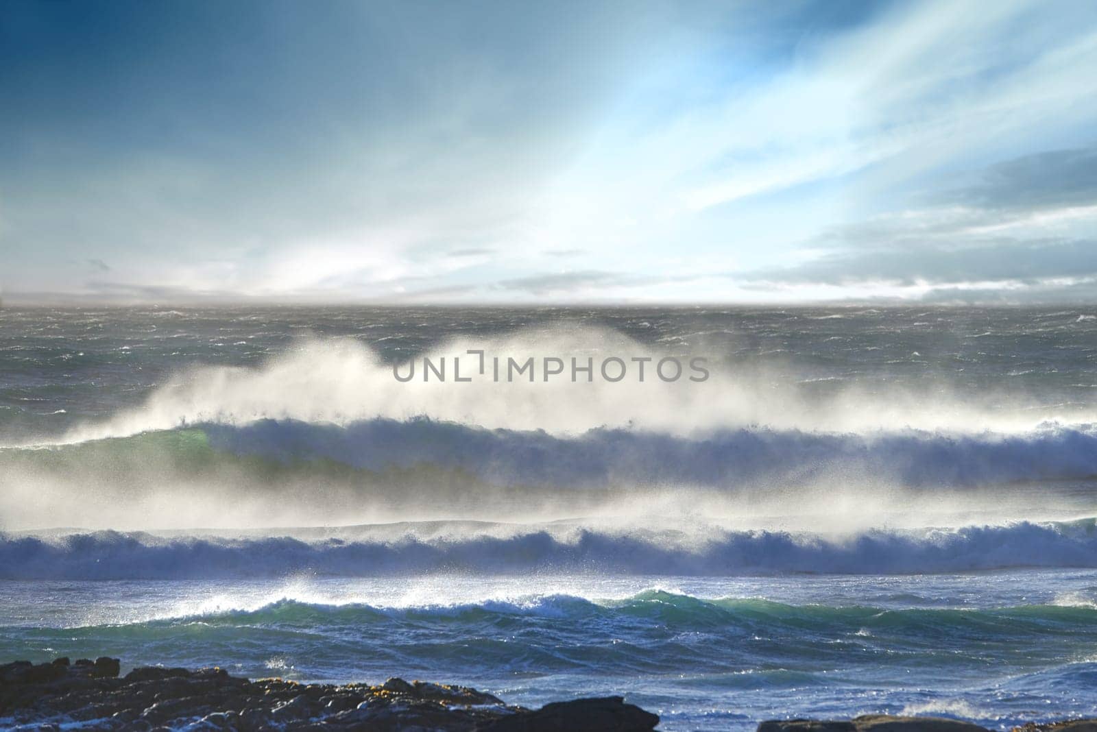 Landscape, wave and water with rocks on beach with sky in nature in summer with storm in Brazil. Spring, air and oceanfront on seashore with sun, coast and outdoors with travel in wind with marine. by YuriArcurs