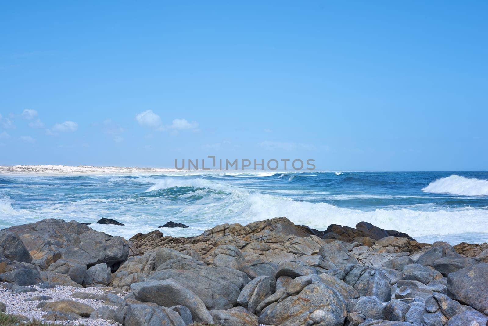 Ocean, waves and rocks on coast of beach in Malaysia for outdoor travel in summer for vacation or holiday. Sea, stone and blue sky with landscape for wallpaper or background, water and nature. by YuriArcurs