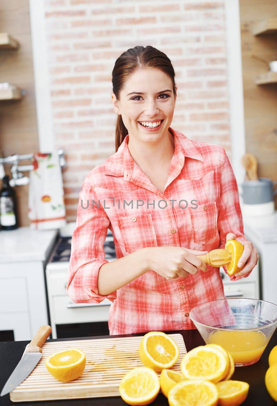 Woman, kitchen and happy or squeeze orange for juice in bowl for health, nutrition and diet with ingredients. Home, portrait and smile with fruit for sweet flavor or lunch snack and fresh food by YuriArcurs