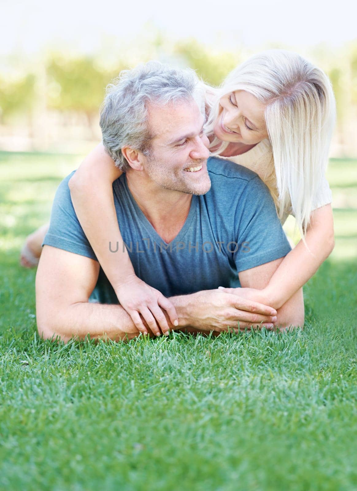 Happy, grass and senior couple in park for bonding, relationship and commitment outdoors on weekend. Love, retirement and mature man and woman embrace for romance, relaxing and marriage in nature by YuriArcurs