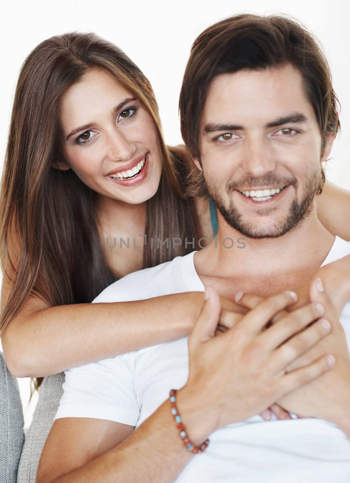 Smile, hug and portrait of couple in studio together with romance, commitment and marriage support. Love, man and happy woman embrace with relationship trust, care and partnership on white background.